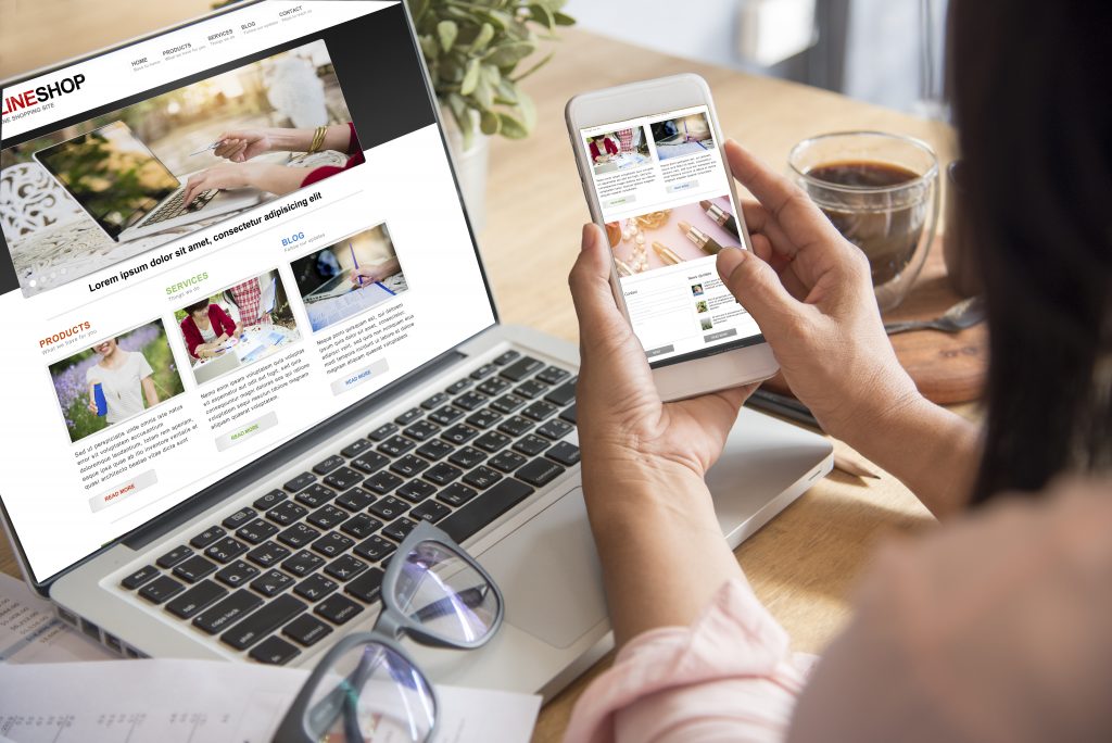 Femme assise devant ordinateur portable ouvert et son smartphone