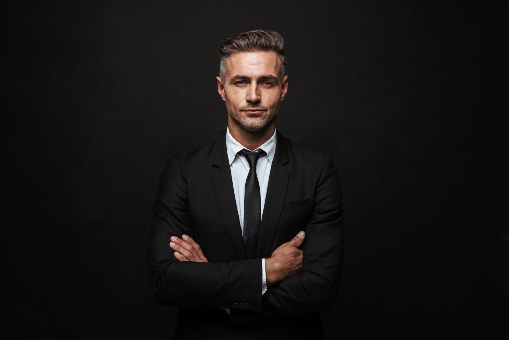 Homme jeune en costume les bras croisés