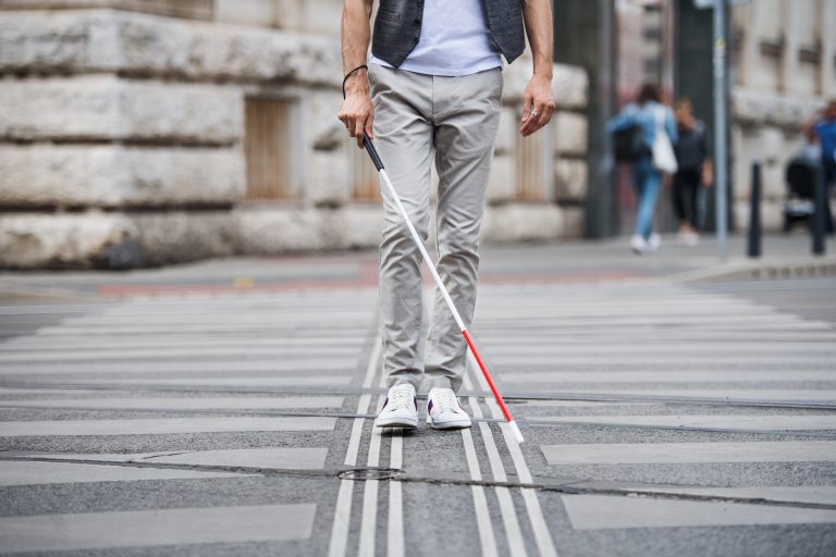 Aveugle avec canne blanche suivant une ligne