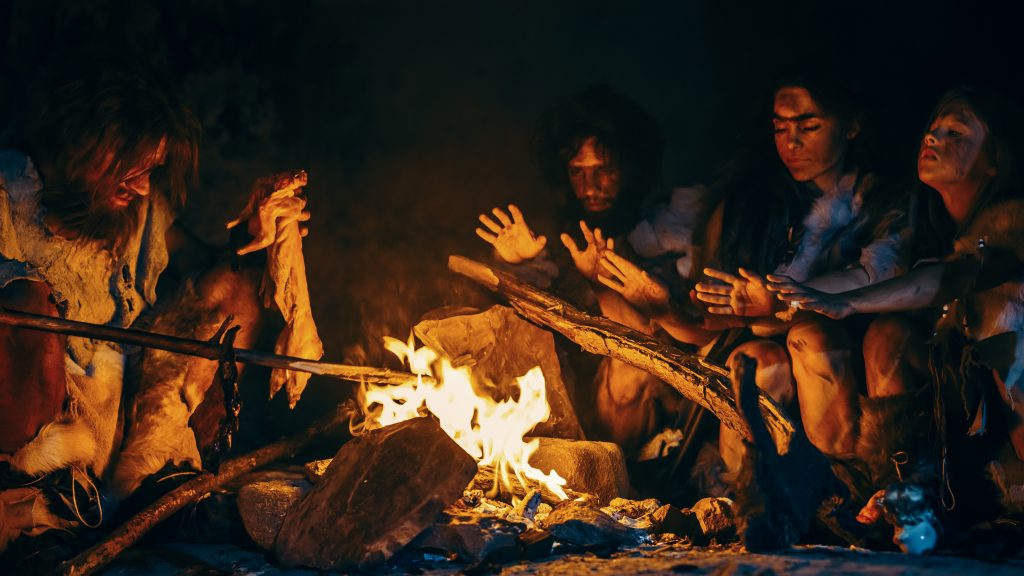 Humains préhistoriques dans la grotte près du feu