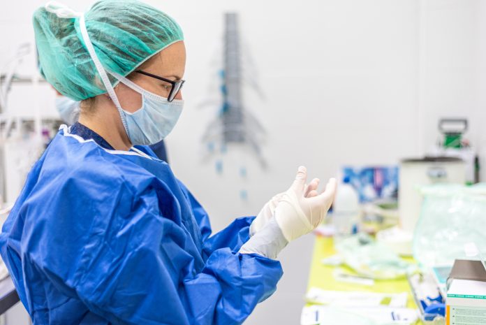Infirmière totalement gantée et protégée en laboratoire