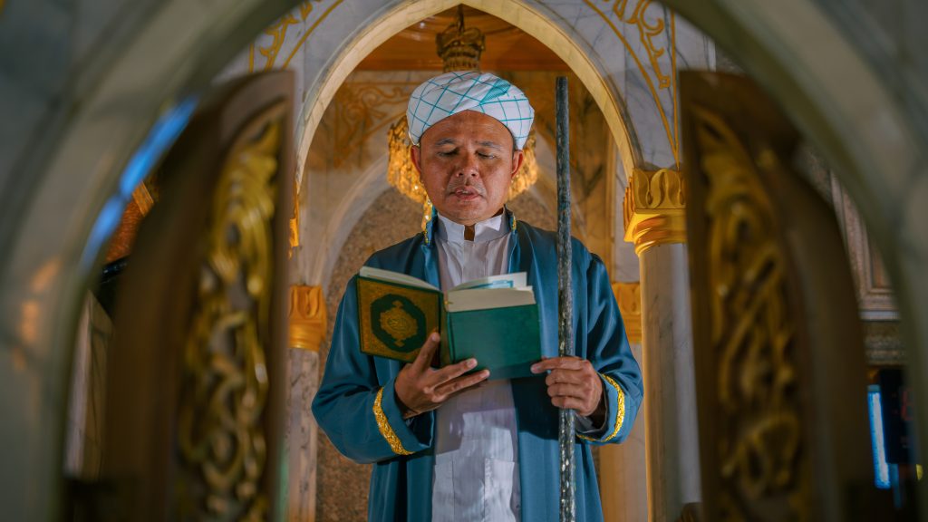 Imam en prière avec un Coran dans les mains