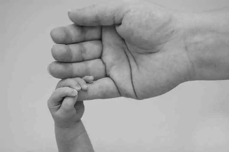 Main adulte avec main d'enfant